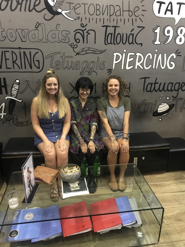 Trois femmes posant devant un mur couvert de graffitis.