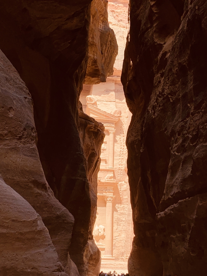 View of Al-Khazneh through a narrow canyon passage.