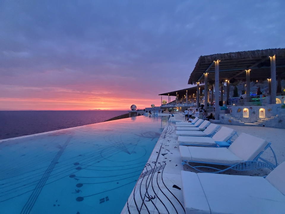 Piscine à débordement surplombant un coucher de soleil vibrant.