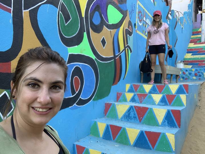 Mur coloré avec de l'art abstrait et deux personnes debout.