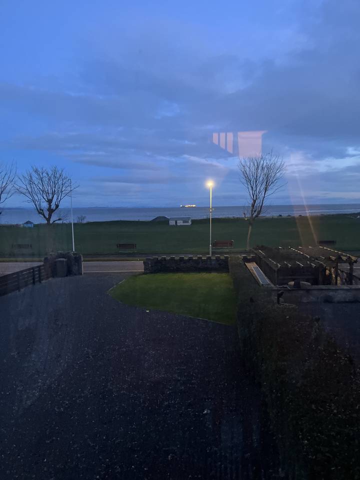 Route près d'un champ avec lampadaire et ciel