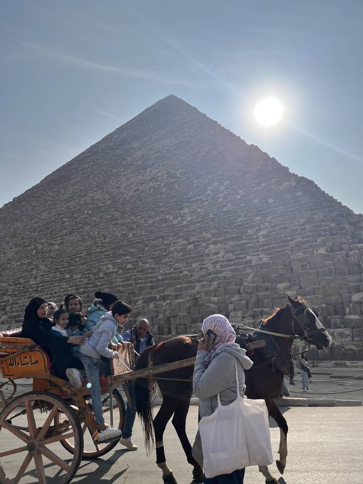 Personnes dans des calèches près d'une pyramide