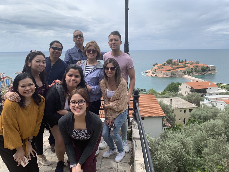 Groupe de touristes posant avec la vue d'une ville insulaire en arrière-plan.