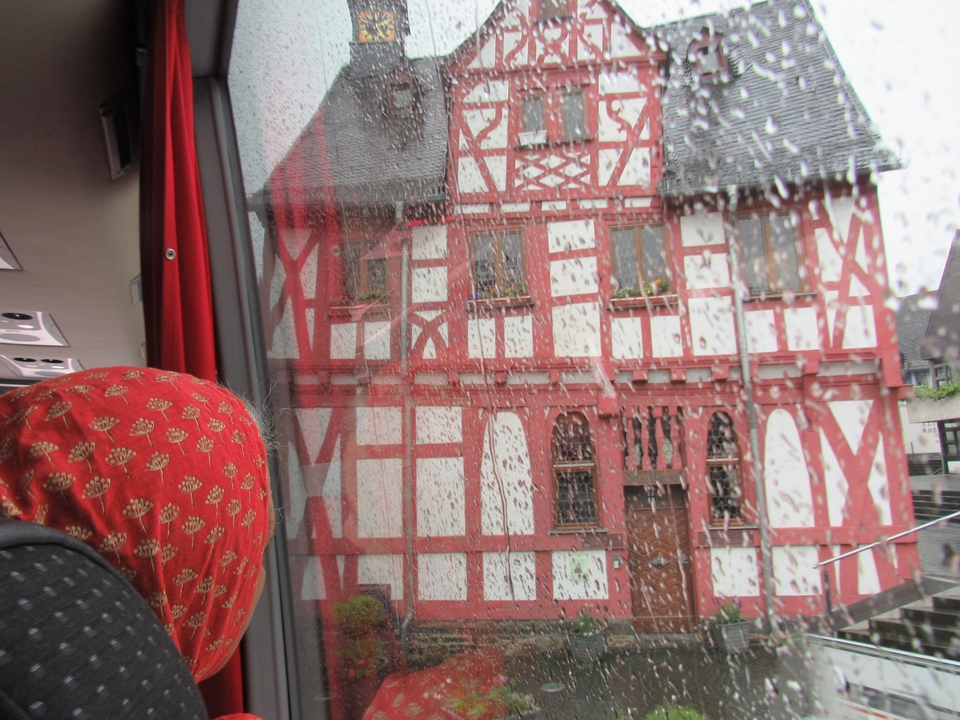 Vue de fenêtre mouillée d'un bâtiment à colombages coloré.