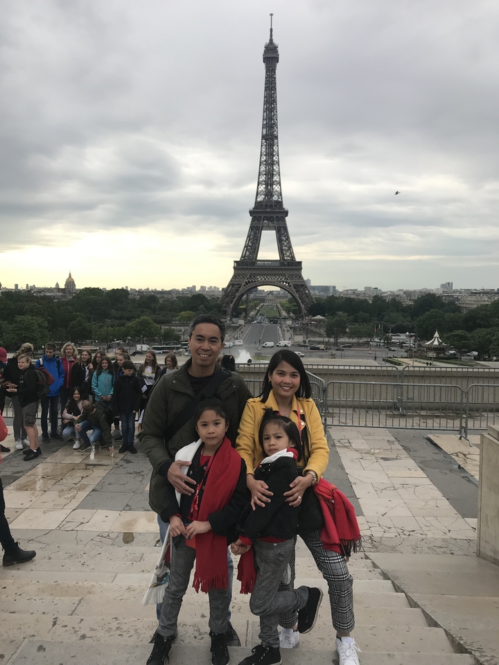 Famille posant devant la tour Eiffel.