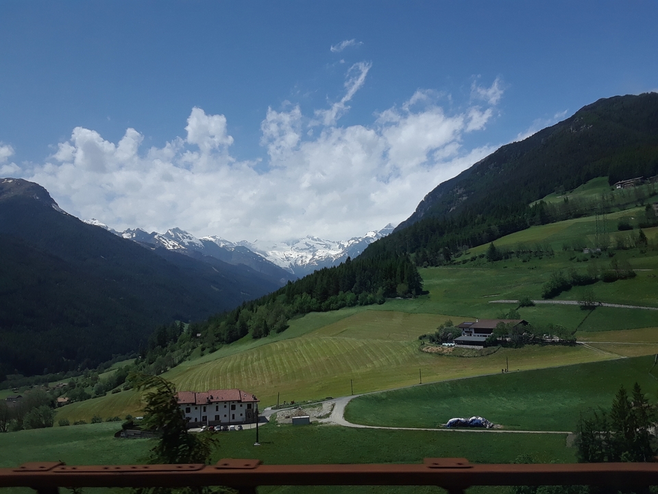 Vue panoramique de champs verts et de montagnes lointaines.
