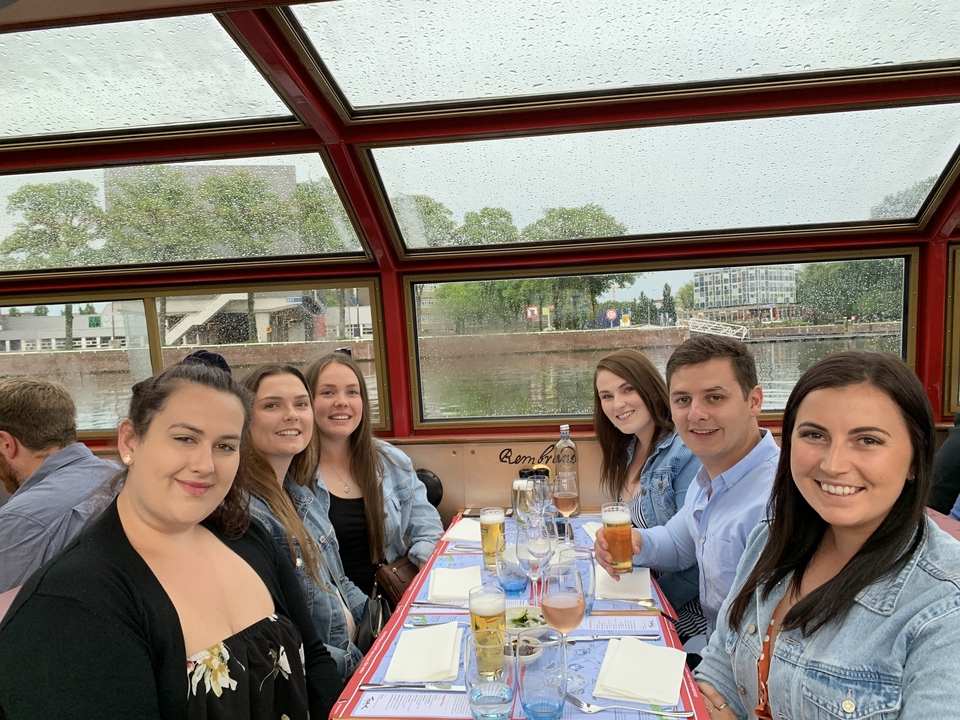 Groupe d'amis assis dans un bateau avec des boissons.