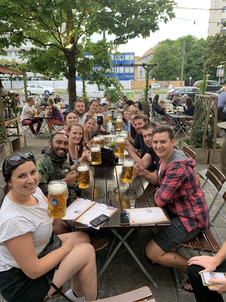 Groupe de personnes profitant d'une bière dans un cadre extérieur.