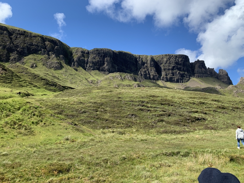 Une vue panoramique sur une chaîne de montagnes avec une personne au premier plan.