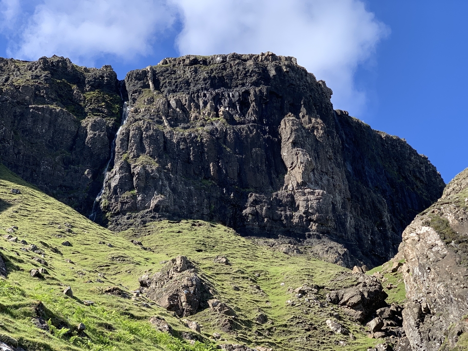 Falaises de montagne avec ciel bleu et nuages épars.