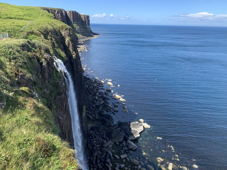 Cascade se jetant d'une falaise dans la mer.