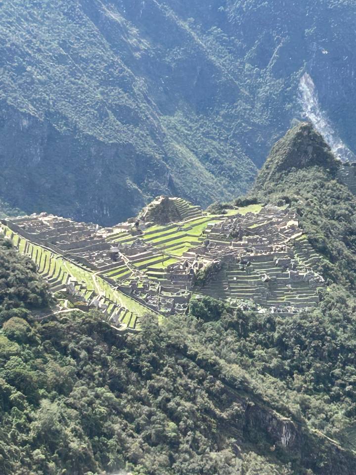 Luftaufnahme der Machu Picchu Ruinen, umgeben von Bergen.