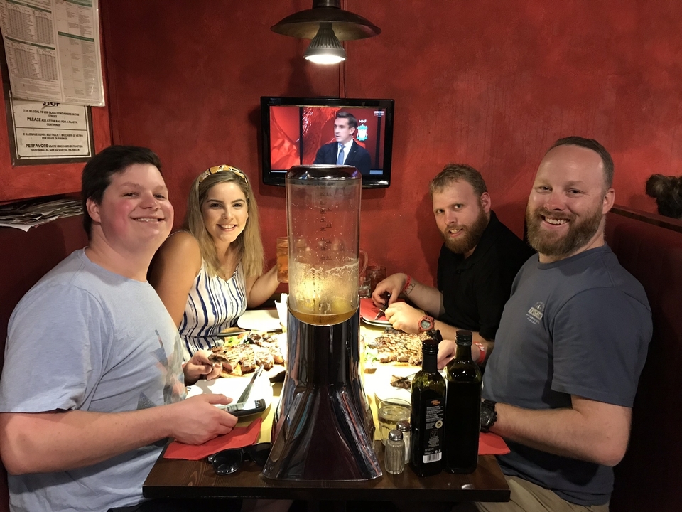 Un groupe de personnes qui dînent à l'intérieur dans un décor rustique.