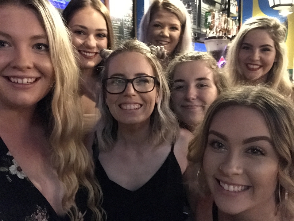 Un groupe d'amis prenant un selfie ensemble à l'intérieur.