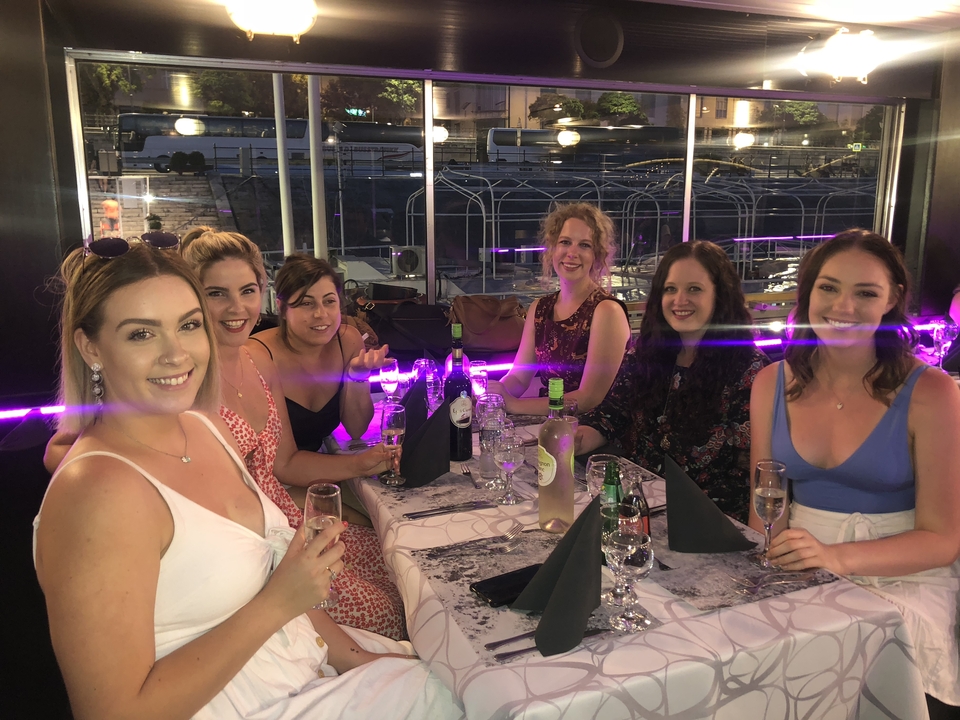 Un groupe de femmes assises à une table de salle à manger avec des boissons.