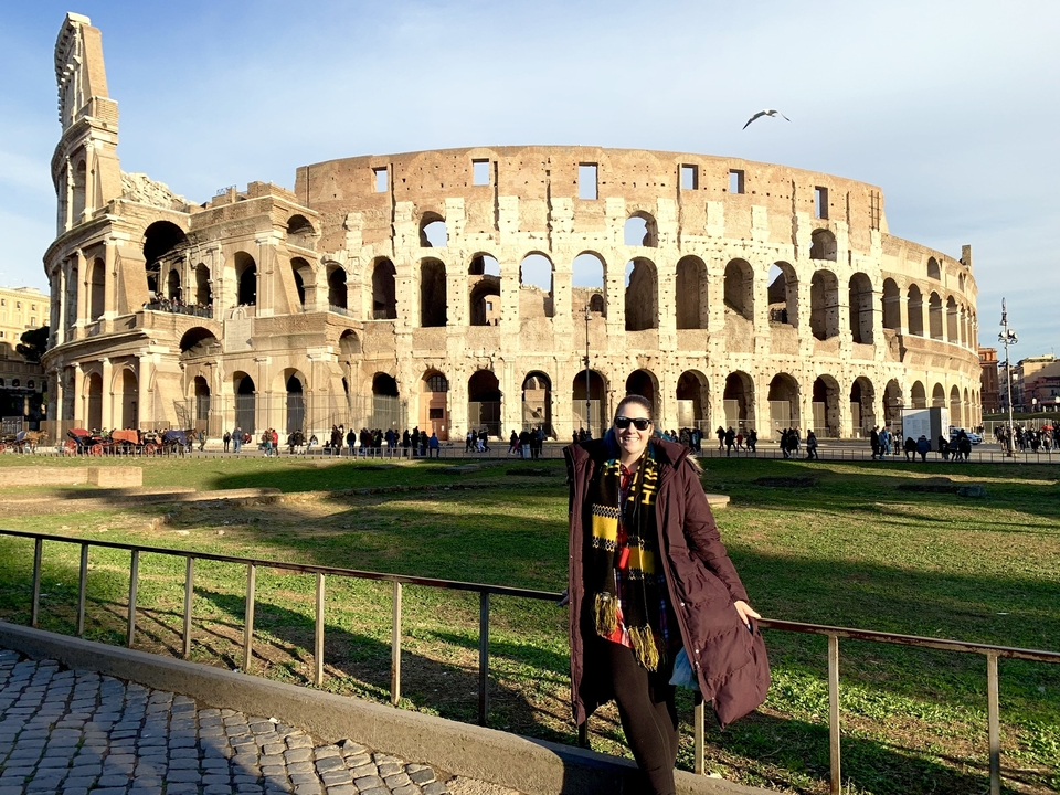 Person posing in front of the Colosseum.