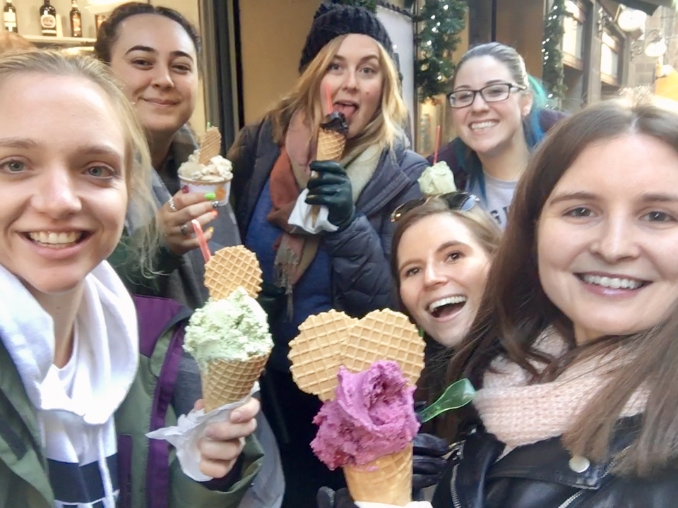 Groupe d'amis mangeant des cônes de glace dans une rue de la ville.