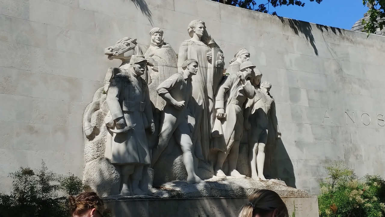Sculpture de plusieurs personnes sculptées dans un mur de pierre.