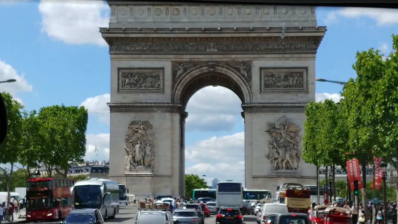 L'Arc de Triomphe entouré par une circulation dense dans la ville.