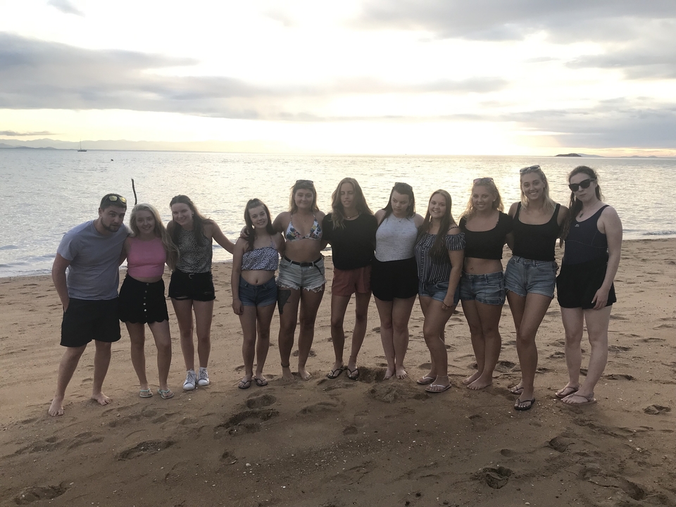 Groupe de personnes debout sur une plage.