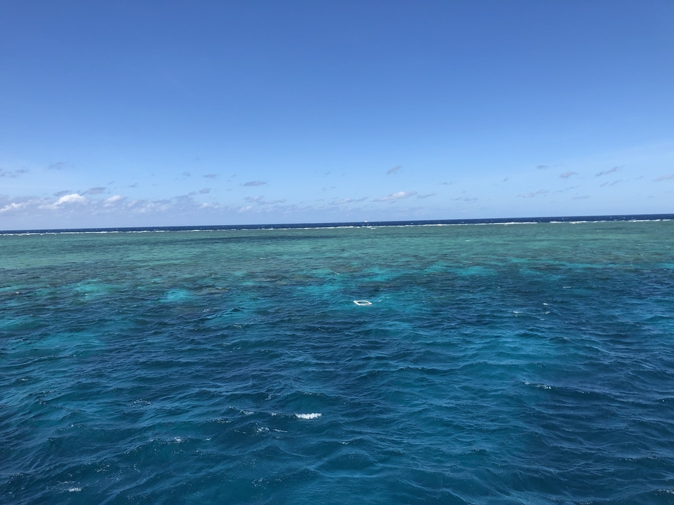 Des eaux océaniques bleu clair sous un ciel ensoleillé.