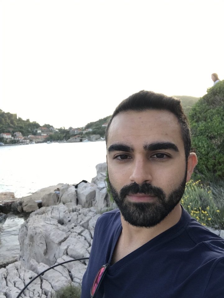 Un portrait d'un homme sur un arrière-plan côtier pittoresque.