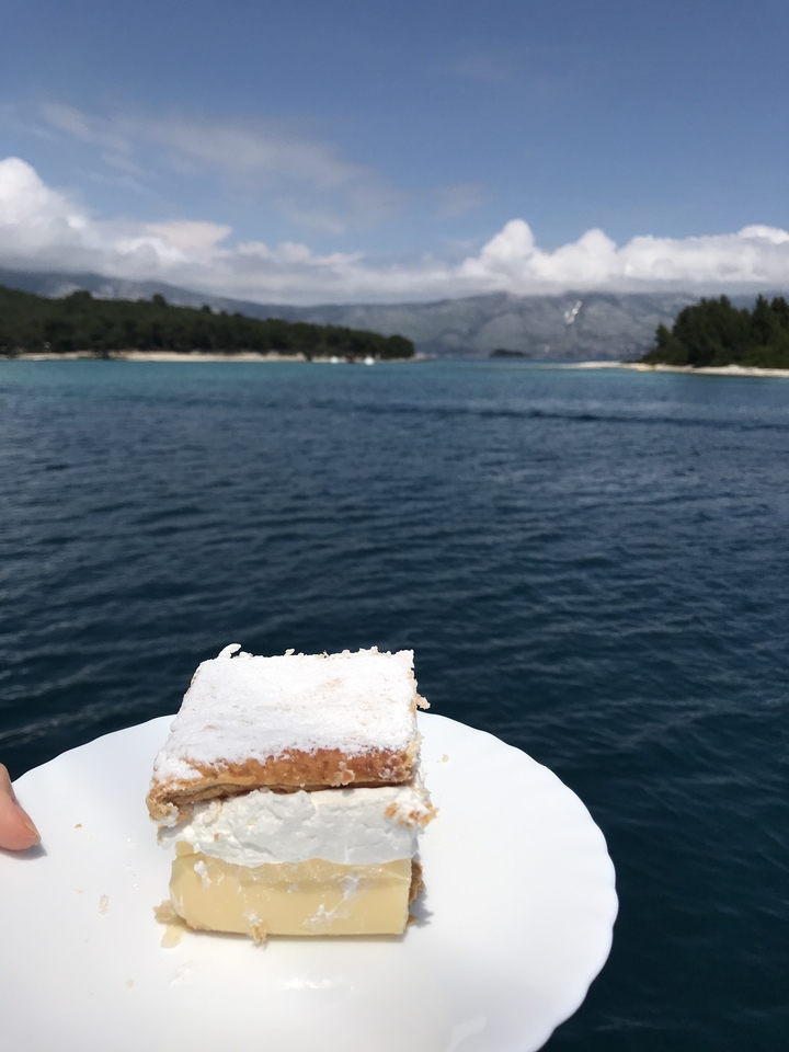 Gros plan d'un dessert sur une assiette avec un lac pittoresque et une forêt en arrière-plan.