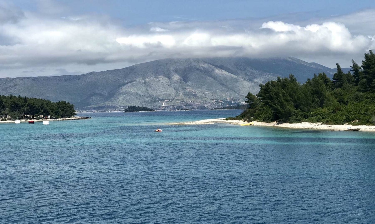 Mer bleue avec un arrière-plan montagneux.