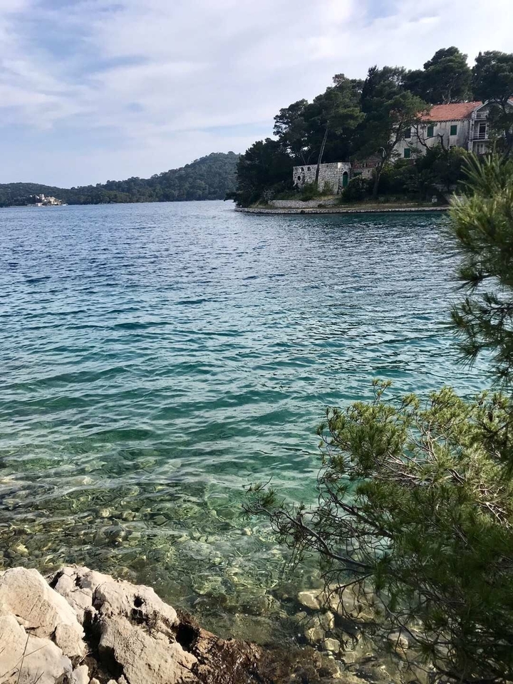 Eau bleue claire avec rivage rocheux.