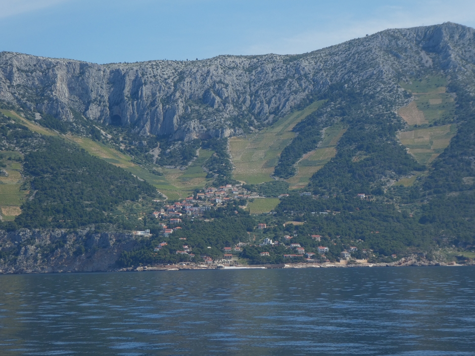 Côte montagneuse avec petit village et vignobles.