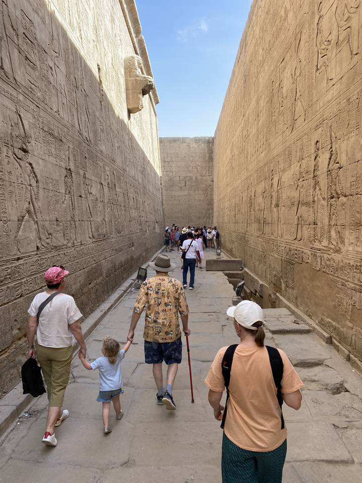 Des gens marchant à travers des ruines antiques avec des hiéroglyphes.