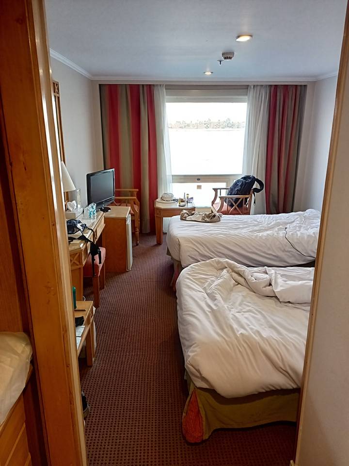 Intérieur d'une chambre d'hôtel avec des lits défaits.