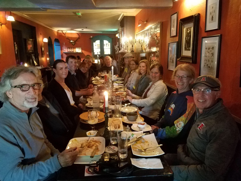 Groupe de personnes dînant ensemble avec des bougies sur la table.