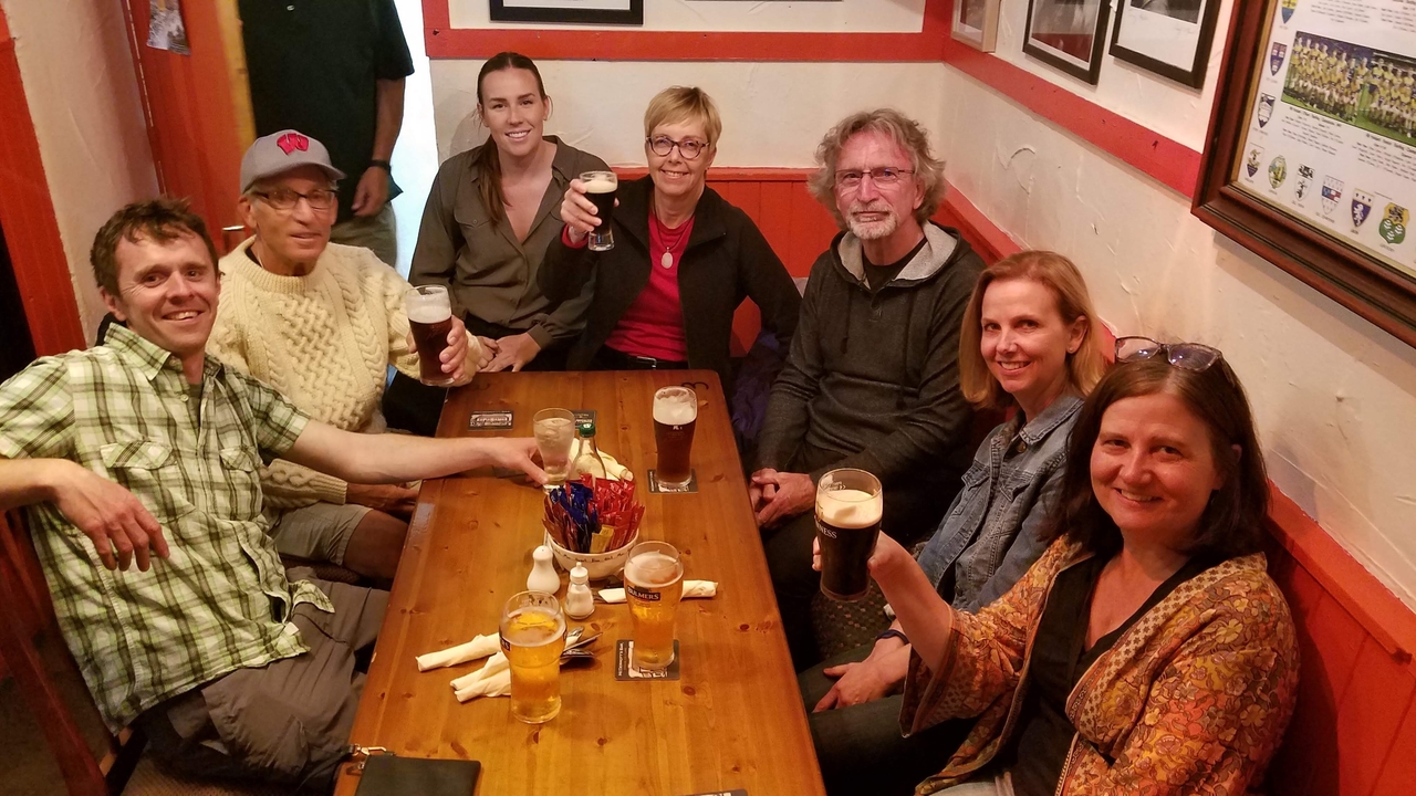Groupe de personnes assises à une table dans un pub intérieur chaleureux.