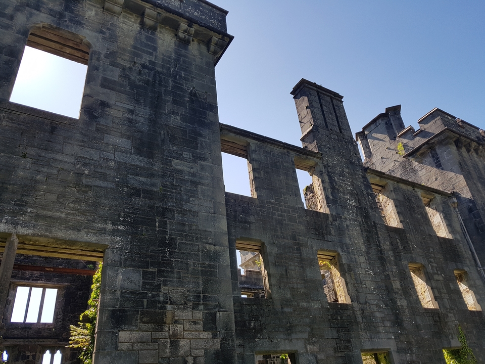 Ruines d'un ancien bâtiment en pierre avec un ciel bleu en arrière-plan.