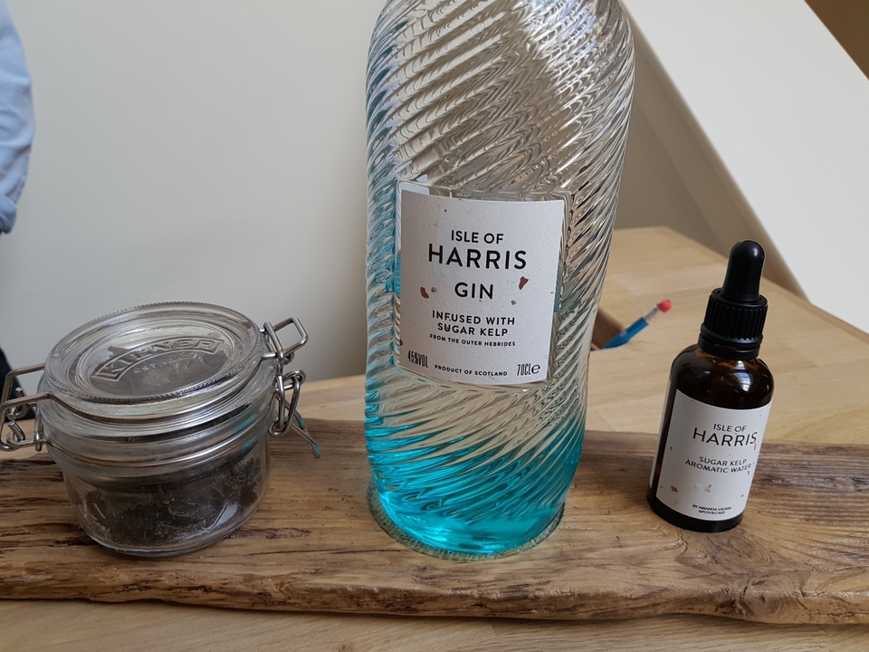 Bouteille de gin de l'île de Harris et autres objets sur une table.