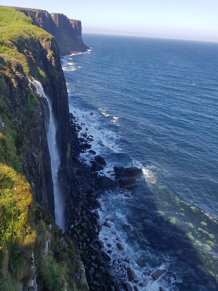 Cascade tombant d'une falaise dans la mer.