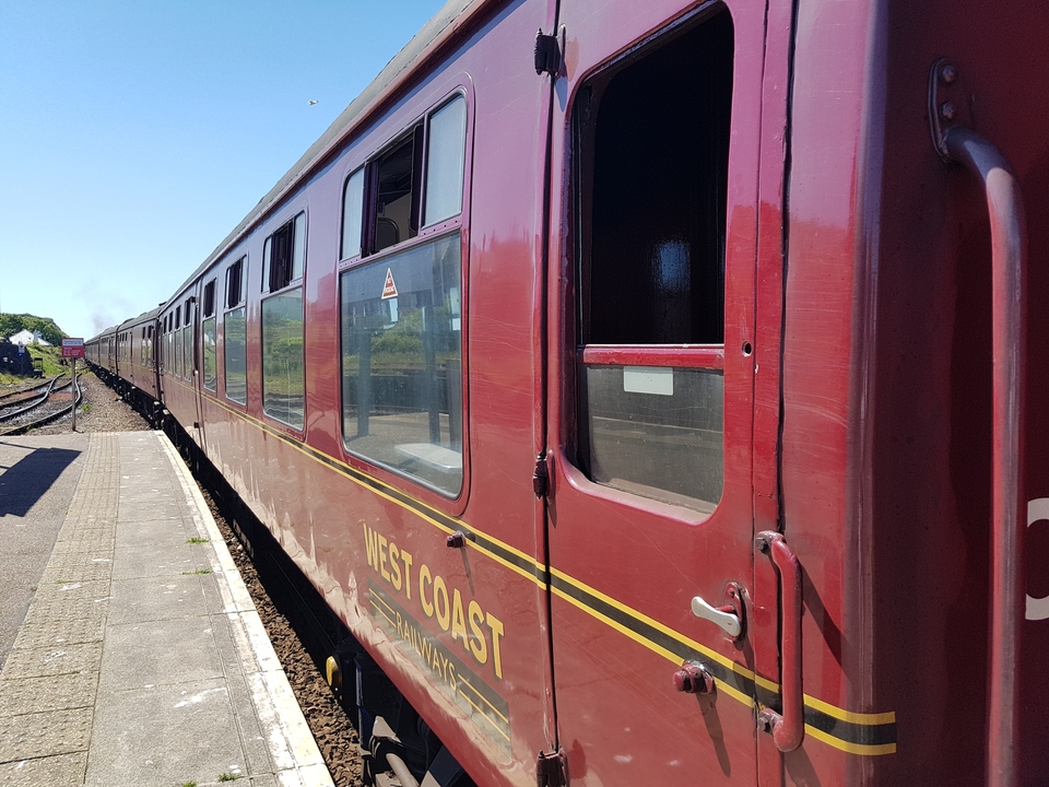 Vieux train dans une gare étiquetée Côte Ouest.