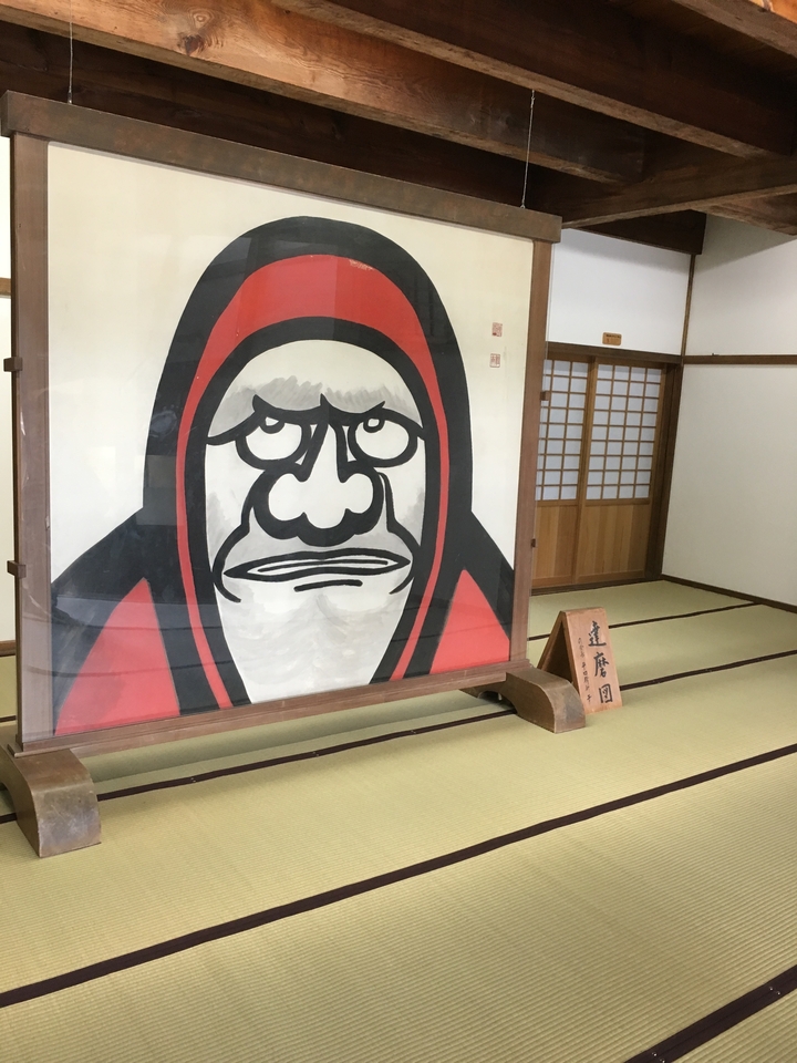 Chambre en bois avec une grande peinture dans un cadre traditionnel japonais.