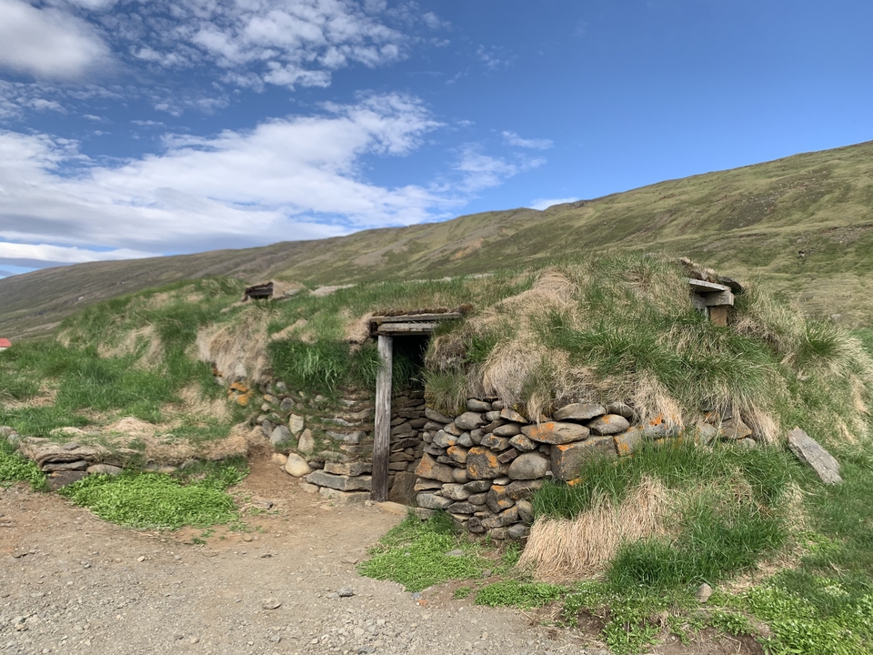 Traditional turf-covered house built into a hillside.