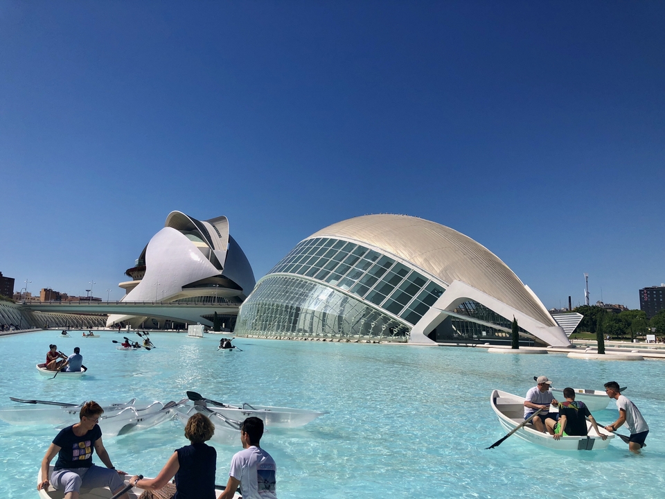Complexe architectural moderne avec piscines et personnes en bateau.