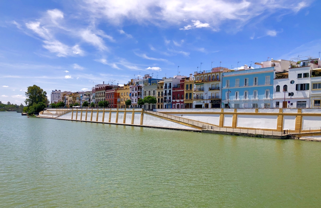 Maisons colorées au bord de la rivière avec un ciel bleu.