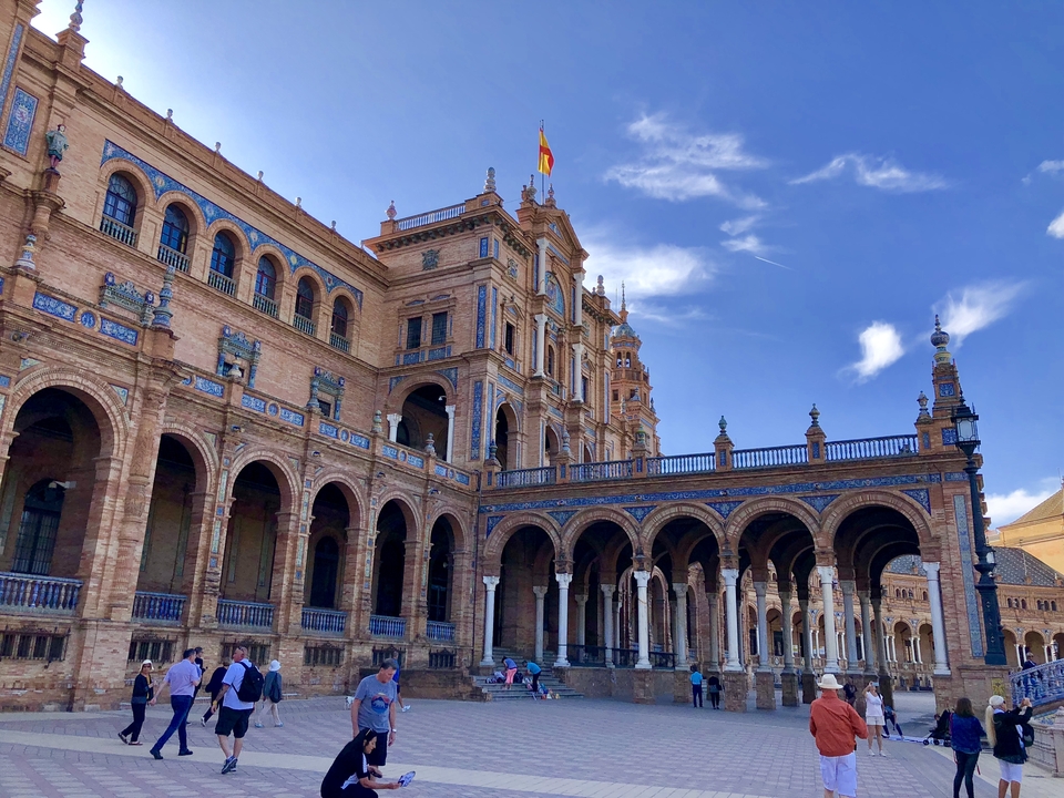 Place d'Espagne avec des touristes, mettant en valeur son architecture impressionnante.