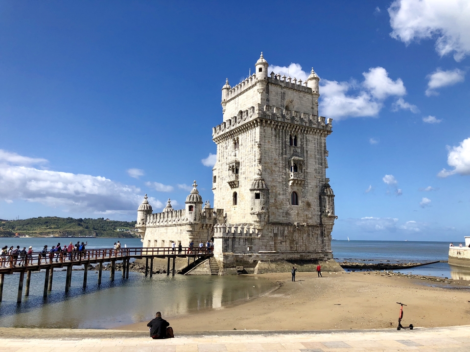 Tour de Belém avec des touristes et une promenade en bois.