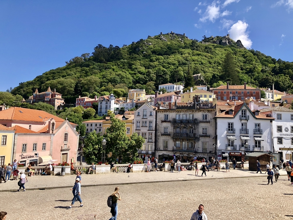 Ville historique colorée avec des touristes qui se promènent.