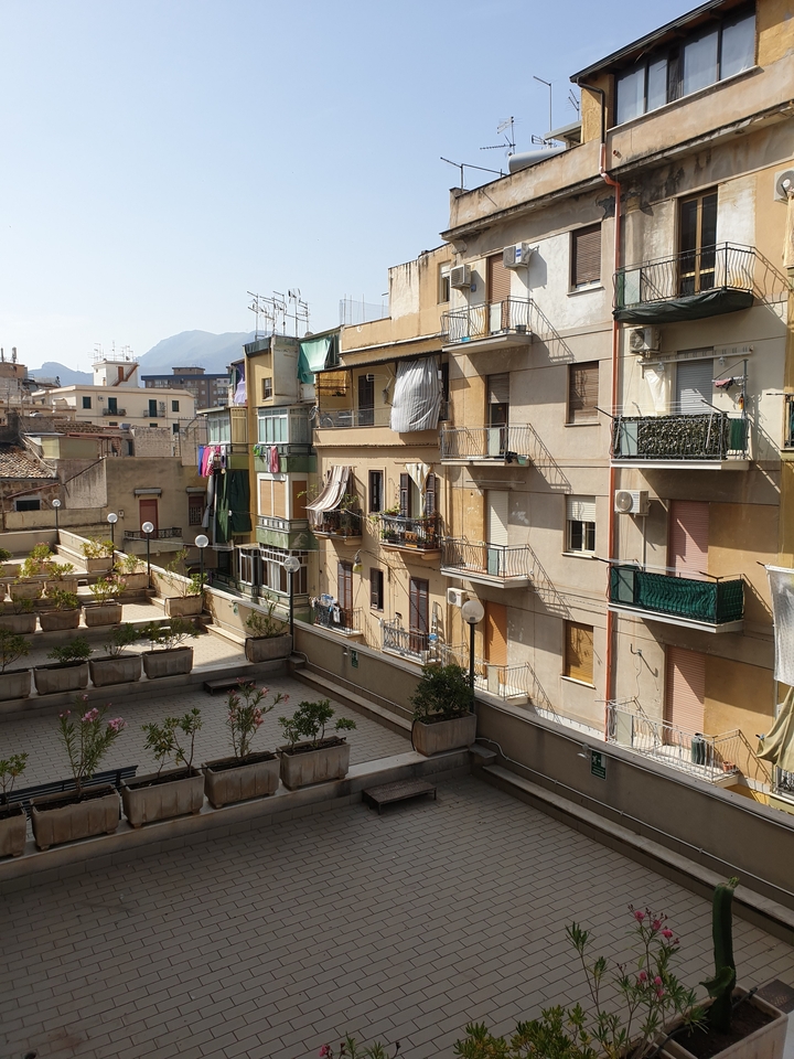 Bâtiments résidentiels avec balcons et un arrière-plan montagneux.