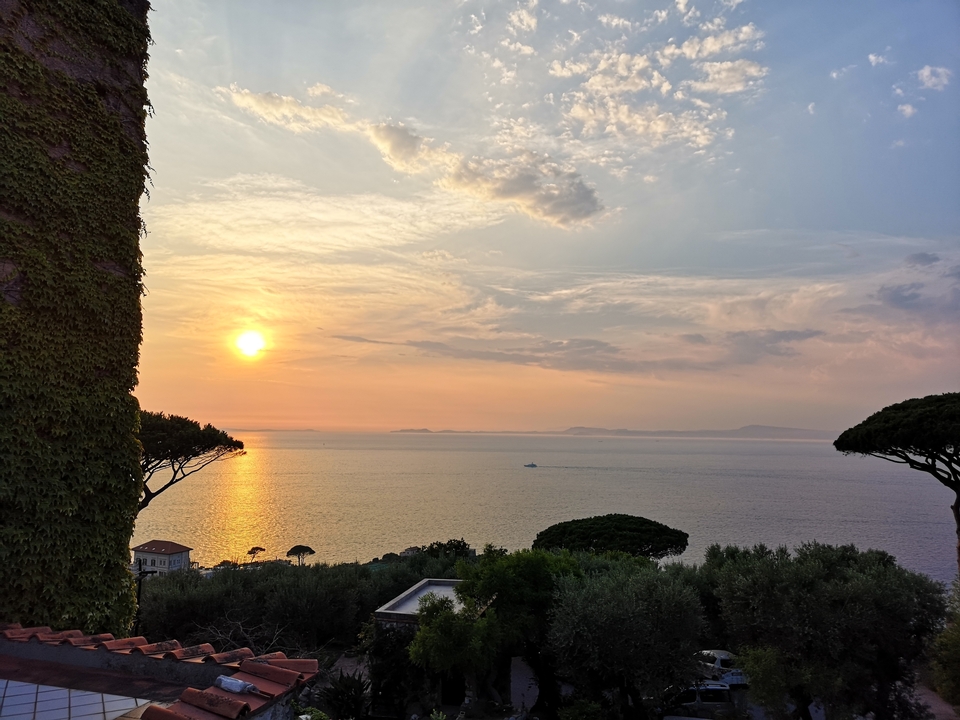 Vue du coucher de soleil sur la mer avec des îles au loin.