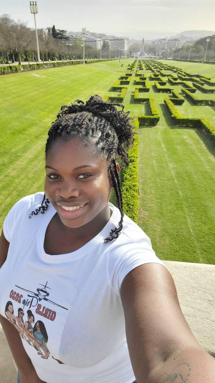 Personne prenant un selfie dans un jardin bien entretenu.