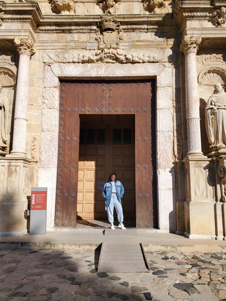 Personne debout dans une grande porte en bois d'un vieux bâtiment.