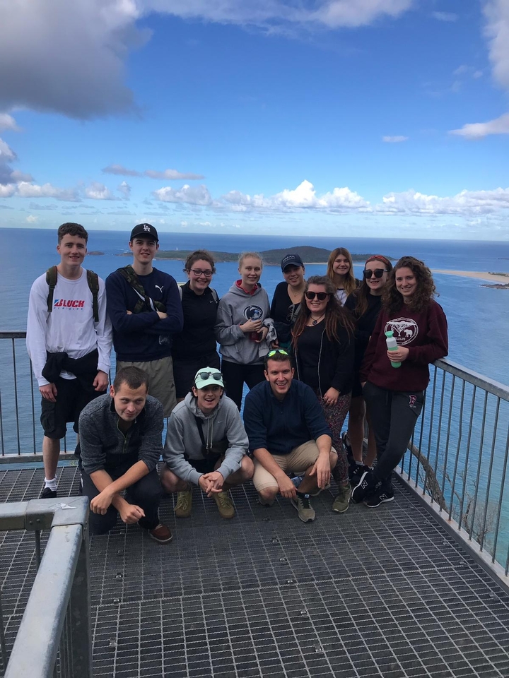 Groupe posant sur une plateforme d'observation surplombant l'océan